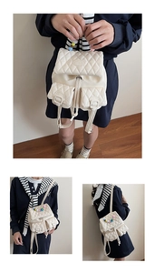 Detail of cream mini backpack featuring quilted texture and colorful bead handle accents