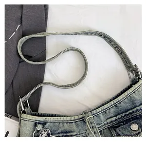 Gros plan d'une bandoulière de sac en jean vintage avec boucle en métal argenté