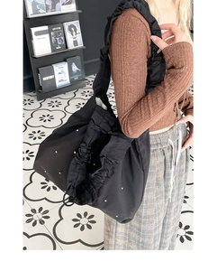 Detail der schwarzen Falten-Tote-Bag mit silbernen Nieten und gerafftem Schultergurt