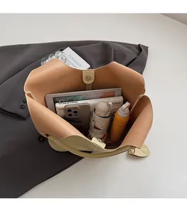 Detail view of large beige bucket bag interior showing spacious capacity for daily essentials