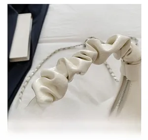 Détail de la poignée froncée style nuage et texture cuir PU sur ce sac crème élégant