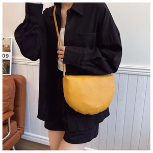 Détail du sac à main jaune en cuir grainé avec bandoulière et fermeture éclair en métal