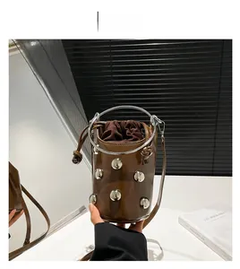 Détail du sac seau marron avec clous argentés, poignée en métal et cordon de serrage