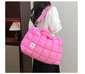 Dettaglio del tessuto trapuntato rosa acceso e tracolla regolabile della grande borsa tote