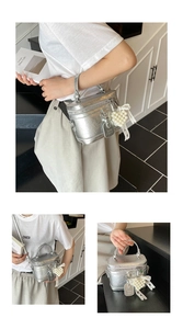 Detail of silver textured square handbag with pearl heart charm and lace ribbon