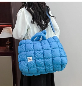 Dettaglio della borsa trapuntata blu con ampie cuciture e morbida texture in nylon