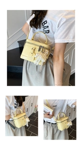 Detail of yellow embossed leather handbag with lace bow charm and metallic zipper