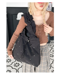Detail der schwarzen Falten-Tasche mit Perlenbesatz und gerafftem Schultergurt