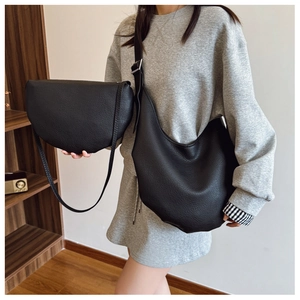 Detail of black lychee grain leather bucket bag and half moon crossbody bag for women