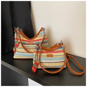 Détail de sacs tissés colorés en deux tailles avec breloques fraise et anses en cuir