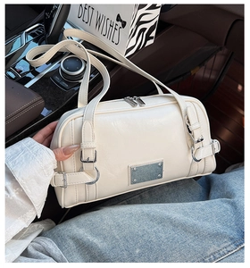 Close-up of white biker style Boston bag with silver metal buckles and double zippers