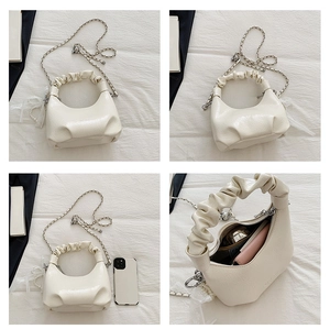 Vue détaillée du sac nuage crème avec breloque en dentelle et capacité de rangement