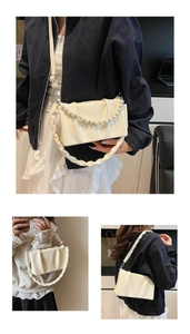 Détail du sac plissé blanc crème avec chaîne en perles et bandoulière froncée
