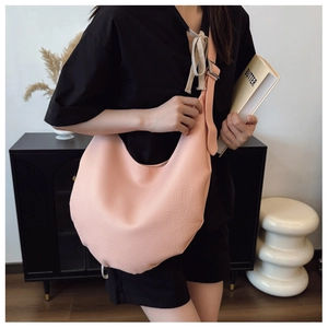 Detail of peach pink hobo bag showing litchi grain leather texture and silver hardware