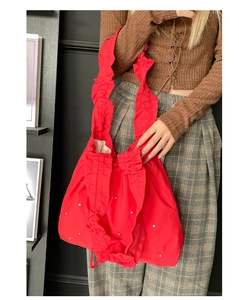 Detailaufnahme der roten Plissee-Einkaufstasche aus Nylon mit eleganten weißen Perlen