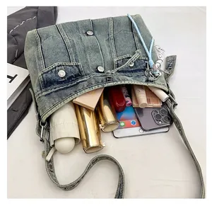 Vue de dessus de l'intérieur spacieux du sac en jean contenant un iPad et un parapluie