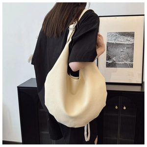 Close-up of beige lychee texture hobo bag with silver buckle and large capacity