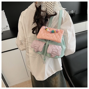 Rear view of mint green quilted backpack with colorful beads handle on a model