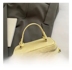 Detail showing the pleated texture and silver metal zipper of this yellow box handbag