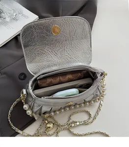 Vue détaillée de l'intérieur d'un sac argenté plissé avec espace pour téléphone et objets