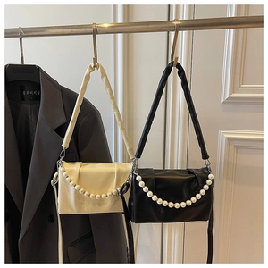Détail de sacs à bandoulière en similicuir plissé avec élégantes chaînes de perles
