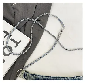 Detail of vintage denim crossbody bag featuring metal chain and denim woven strap
