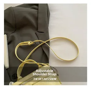 Detail of adjustable thin shoulder strap on a lemon yellow textured bucket handbag