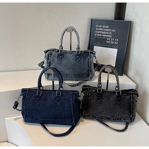 Trois sacs cabas en jean vintage bleu et gris avec boucles rétro sur présentoir blanc