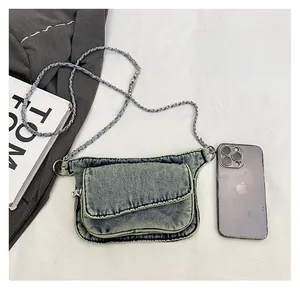 Detail view of denim crossbody bag size comparison next to a smartphone device