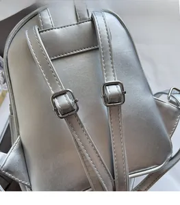 Detail of adjustable silver leather backpack straps with high-quality metal buckles