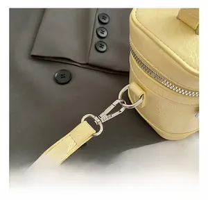 Detailed shot of silver metal swivel hook and stitching on yellow crossbody bag