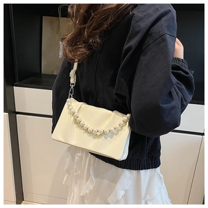Détail du sac bandoulière plissé crème avec chaîne en perles et fine bandoulière réglable