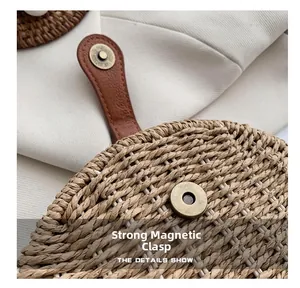 Detail of a semi-circular straw bag showing the strong magnetic buckle and leather strap