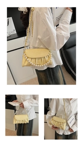 Détail du sac à bandoulière plissé jaune beurre avec perles et poignée en chaîne