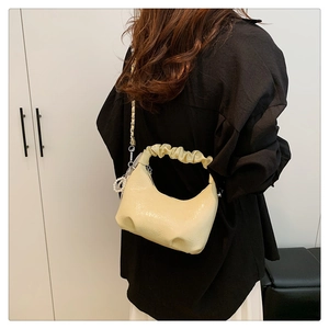 Détail du sac nuage crème avec poignée plissée et élégante breloque en perles fines