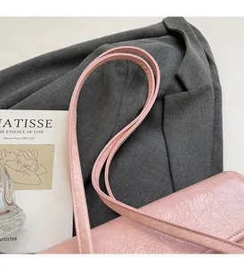 Detail of pink pleated faux leather tote bag with slim shoulder strap and matte finish