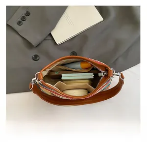 Détails intérieurs du sac tissé arc-en-ciel montrant les poches et objets quotidiens