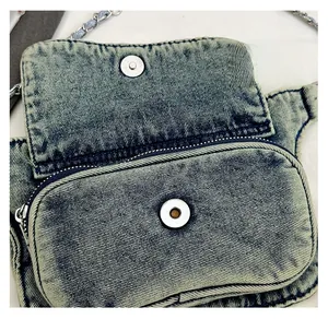 Macro view of magnetic snap closure and metal zipper on blue denim crossbody bag