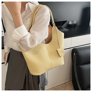 Litchi texture yellow leather bucket bag with mini pouch shown on shoulder