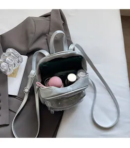 Silver metallic mini backpack showing spacious interior for tablet, phone and cosmetics
