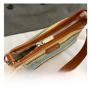 Détail du sac tissé coloré avec étiquette logo en cuir et fermeture éclair métallique