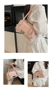 Detail of pink patent leather Boston bag with silver hardware and adjustable handle straps