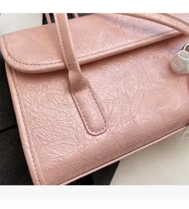 Close-up of pink crinkled texture fabric and stitching details on the handle shoulder bag