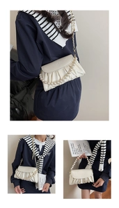 Détail du sac nuage plissé blanc cassé avec poignée en perles et chaîne dorée