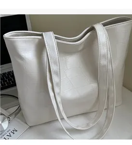 Detail of white crocodile embossed tote bag texture with durable double handles