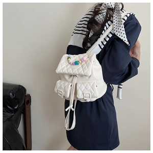 Quilted beige backpack featuring colorful candy-colored bead handle and drawstring closure