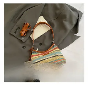 Vue détaillée du sac tissé multicolore avec poignées en cuir et pendentif fraise