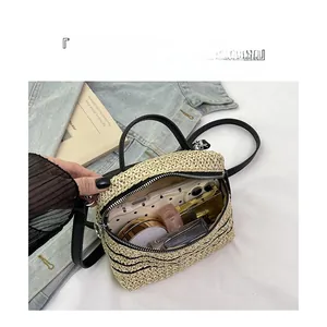 Détail du sac bandoulière beige tissé main montrant le rangement pour téléphone et maquillage