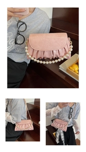 Détail du sac rose avec poignée en perles élégante et design plissé texturé