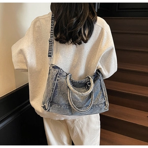 Détail du sac cabas en denim vintage bleu montrant la sangle réglable et la texture lavée